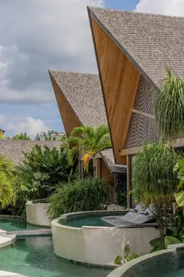 a resort with a swimming pool and a building at Beyond Bayou in Seminyak