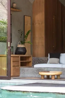 a bedroom with a bed and a table next to a pool at Beyond Bayou in Seminyak