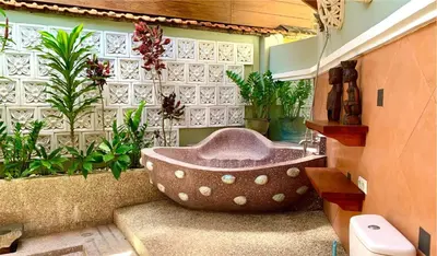 a large bath tub in a bathroom with plants at Villa Naga Maya in Legian