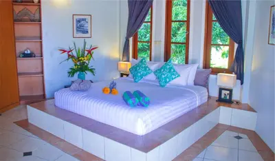a bedroom with a large white bed with shoes on it at Villa Naga Maya in Legian