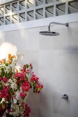 a light on a wall with flowers on it at CASA MALEH 2BR lively villa in kayuaya seminyak in Seminyak