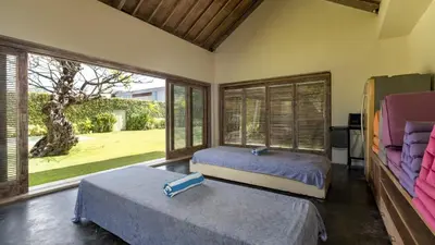 a bedroom with two beds and a large window at Casa Mateo Villa in Seminyak