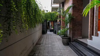 an alley with plants on the side of a building at Kubu De Uma in Seminyak