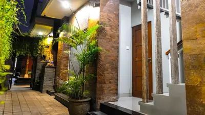 a corridor of a building with plants and a door at Kubu De Uma in Seminyak