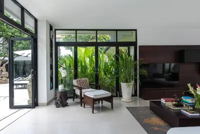 a living room filled with furniture and windows at Villa Anaya Manis in Seminyak