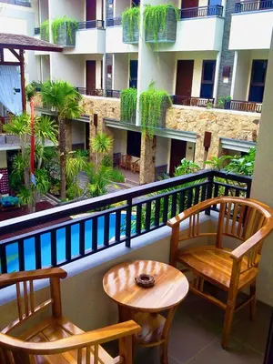 two chairs and a table on the balcony of a building at Manggar Indonesia Hotel in Kuta
