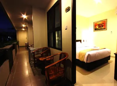 a hotel room with a bed and a table and chairs at Manggar Indonesia Hotel in Kuta