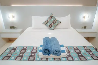 a bed with two towels and two pillows on it at 4 BEDROOM VILLA KUTA REGENCY B10 in Kuta