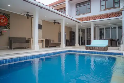 a swimming pool in front of a house at 4 BEDROOM VILLA KUTA REGENCY B10 in Kuta