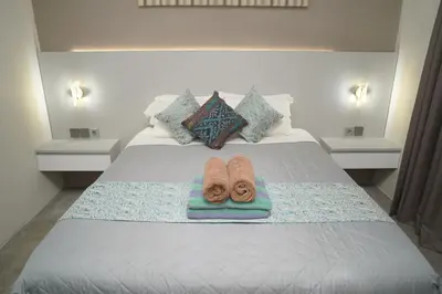 a bed with two slippers sitting on top of it at 4 BEDROOM VILLA KUTA REGENCY B10 in Kuta