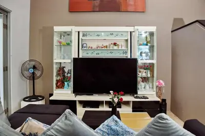 a living room with a television in a white cabinet at 4 BEDROOM VILLA KUTA REGENCY B10 in Kuta