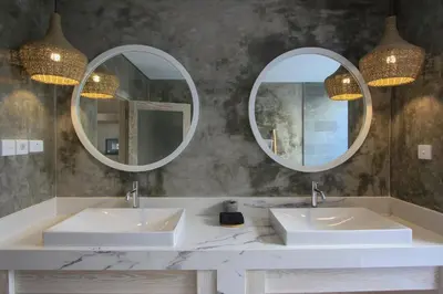a bathroom with two sinks and two mirrors at Sari Alexa Villas in Seminyak