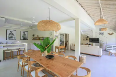 a dining room and living room with a table and chairs at Sari Alexa Villas in Seminyak