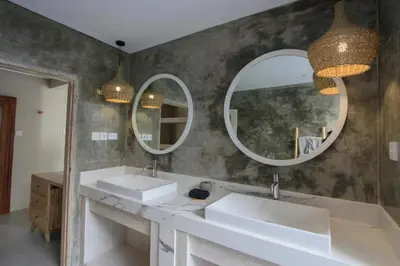 a bathroom with two sinks and two mirrors at Sari Alexa Villas in Seminyak