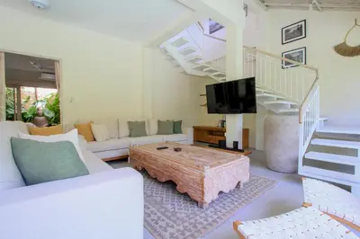 a living room with a couch and a tv at Sari Alexa Villas in Seminyak