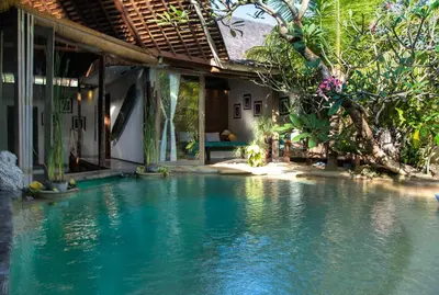 a house with a pool of water in front of it at Phinisi Villas - Seminyak Beach in Seminyak