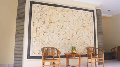 a large wall mural with two chairs and a table at Pondok Mirah in Kuta