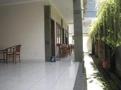 an empty porch of a house with chairs and tables at Pondok Mirah in Kuta