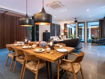 a dining room with a large wooden table and chairs at Villa Castil di Udara by Villa Finder in Kerobokan