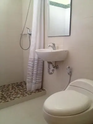 a bathroom with a white toilet and a sink at Puri Clinton Bali in Nusa Dua
