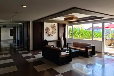 a lobby with couches and chairs in a building at The Kana Kuta Hotel in Kuta