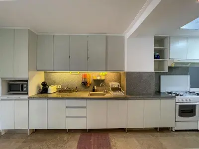 a kitchen with white cabinets and a sink at Beach House Canggu - 150m Berawa beach in Canggu