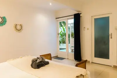 a bedroom with a bed and a large window at Mara Villa, Garden & Pool, 2 min to Seminyak Beach in Seminyak