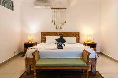a dog sitting on a bed in a bedroom at Mara Villa, Garden & Pool, 2 min to Seminyak Beach in Seminyak