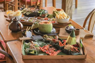 a table with a buffet of food on it at Amnaya Resort Nusa Dua in Nusa Dua