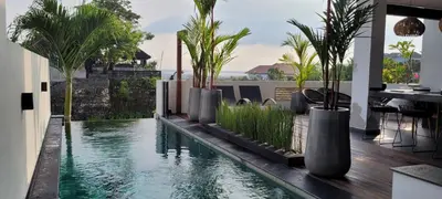 a house with a pool with palm trees in it at Villa Mimpi Bali in Jimbaran