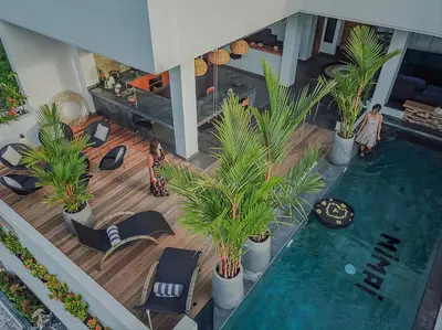 an overhead view of a pool with palm trees and chairs at Villa Mimpi Bali in Jimbaran
