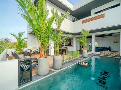 a house with a swimming pool with palm trees at Villa Mimpi Bali in Jimbaran