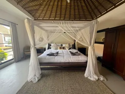 a bedroom with a bed with a canopy at de CINTA Villa - KUTA - 6 bedrooms - Heart of Kuta in Kuta