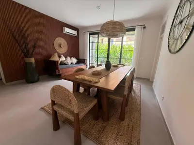 a dining room with a wooden table and chairs at de CINTA Villa - KUTA - 6 bedrooms - Heart of Kuta in Kuta
