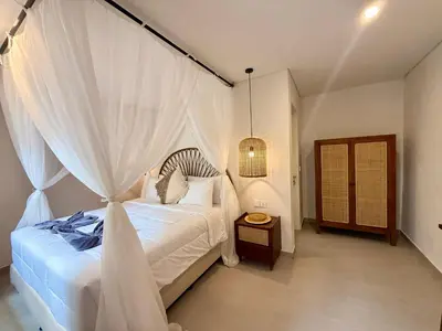 a bedroom with a white bed with a canopy at de CINTA Villa - KUTA - 6 bedrooms - Heart of Kuta in Kuta