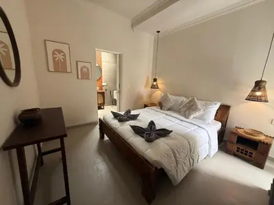 a bedroom with a bed with black bows on it at de CINTA Villa - KUTA - 6 bedrooms - Heart of Kuta in Kuta