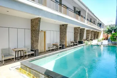 a pool in a hotel with tables and chairs at Lega Legi Town House Seminyak by The Lavana in Seminyak