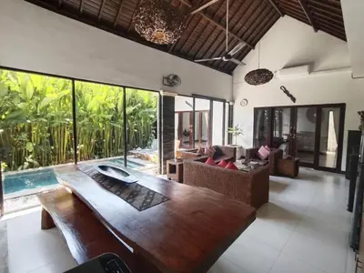 a living room with a wooden table and a pool at Villa CRIS - Heart of LEGIAN 3 Bedrooms, 3 Bathrooms in Legian