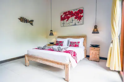 a bedroom with a bed with red pillows at Villa CRIS - Heart of LEGIAN 3 Bedrooms, 3 Bathrooms in Legian