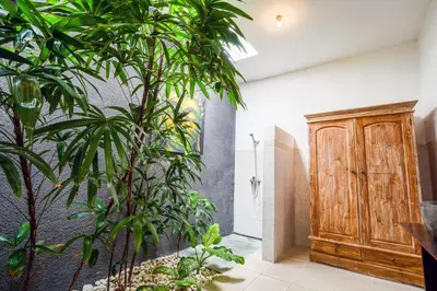 a bathroom with green plants and a wooden cabinet at Villa CRIS - Heart of LEGIAN 3 Bedrooms, 3 Bathrooms in Legian