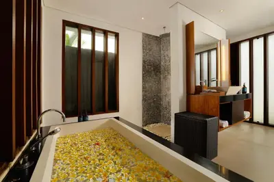 a bathroom with a bath tub filled with lots of flowers at Jimbaran Bay Villas by Nakula in Jimbaran