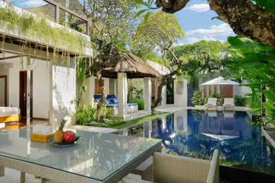 a villa with a swimming pool and a dining area at Jimbaran Bay Villas by Nakula in Jimbaran