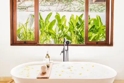 a bath tub in a bathroom with a window at Villa Baladeva - 5 BDR Luxury Villa with huge private Pool in Kuta