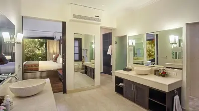 a bathroom with two sinks and a bedroom with a bed at Villa Avalon by Elite Havens in Canggu