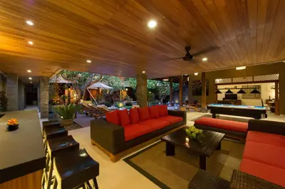 a living room with a red couch and a pool table at Villa Kinaree Estate in Seminyak