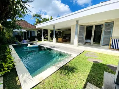 a swimming pool in front of a house at Villa Biru - 500m Batubelig beach in Canggu