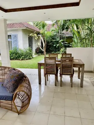 a wooden table and chairs in a patio at Villa Biru - 500m Batubelig beach in Canggu
