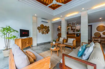 a living room with a couch and a tv at Canggu Escape Villa By Island Escape in Canggu