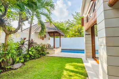 a house with a garden and a swimming pool at Canggu Escape Villa By Island Escape in Canggu