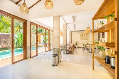 an open living room with sliding glass doors and a pool at Villa Tokyo - 3 BDR Private Villa - 3 min walk to KU DE TA beach in Kuta